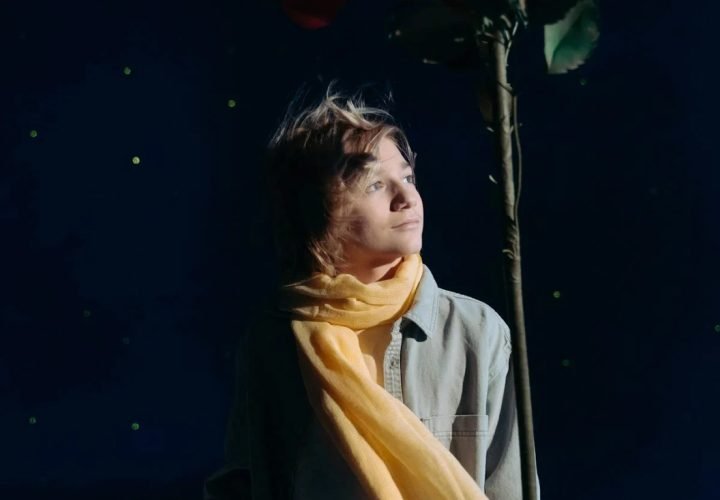 boy-with-yellow-scarf-holding-a-red-flower-7182065